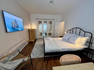 a bedroom with a bed and a tv on the wall at Hogland Apartments - 3 in Kotka