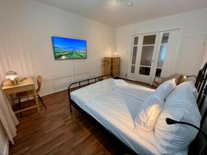 ein Schlafzimmer mit einem Bett und einem TV an der Wand in der Unterkunft Hogland Apartments - 3 in Kotka