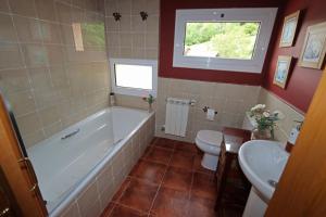 a bathroom with a tub and a toilet and a sink at Baigorri in El Llano +17 photos