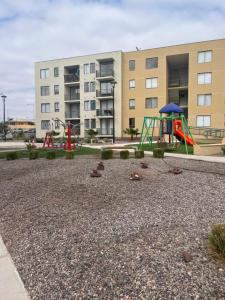 um parque infantil com um escorrega em frente a um edifício em descanso y paz em Caldera