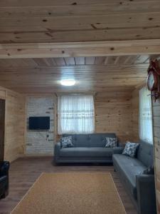 a living room with a couch and a tv at Saklı Bahçe Suite in Uzungöl