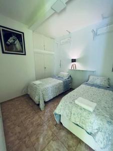 1 dormitorio con 2 camas y una foto en la pared en Departamento, San Juan Centro en San Juan