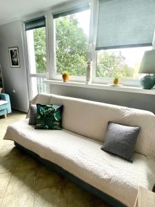 a white couch in a living room with windows at Apartament Słoneczny in Świnoujście