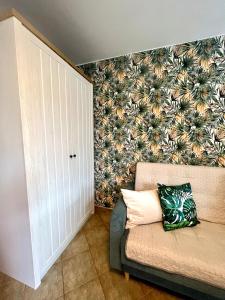 a living room with a couch and a flowery wall at Apartament Słoneczny in Świnoujście