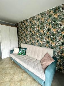 a couch in a living room with a wall at Apartament Słoneczny in Świnoujście