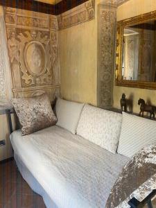 een wit bed in een kamer met een spiegel bij Villetta la Colombaia in Carzano