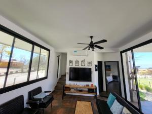 a living room with a ceiling fan and a flat screen tv at CASAS Viñedos de Cafayate Alquiler Temporario in Cafayate