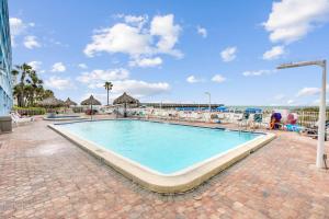 a swimming pool at a resort with the ocean in the background at Sand Dollar 107 in Clearwater Beach