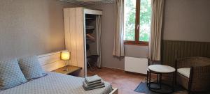 um quarto com uma cama, uma mesa e uma cadeira em B&B Auberge Verdon em La Palud sur Verdon