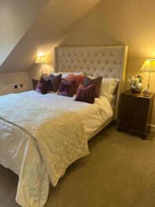 Un dormitorio con una cama grande con almohadas. en The Croft, en Cowbridge