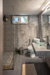 La salle de bains est pourvue de toilettes, d'un lavabo et d'une baignoire. dans l'établissement Unique Luxury House, à Athènes