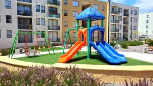 un parque infantil frente a un edificio de apartamentos en descanso y paz, en Caldera