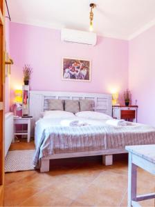 een slaapkamer met een groot bed met paarse muren bij Lady Lavender House in Balatonfüred