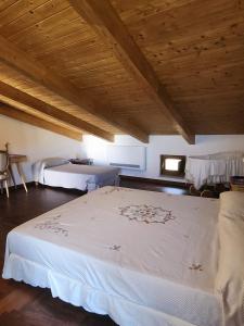 1 dormitorio con 1 cama blanca grande y techo de madera en B&B Il borgo incantato, en Laureana Cilento