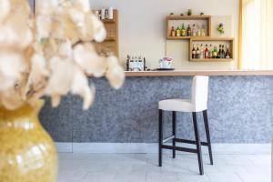 Hotel Sanremo في ريميني: يوجد بار به كرسي أبيض و مزهرية