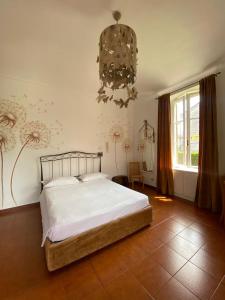 Schlafzimmer mit einem Bett und einem Kronleuchter in der Unterkunft Novecento Charming Room in Avigliana