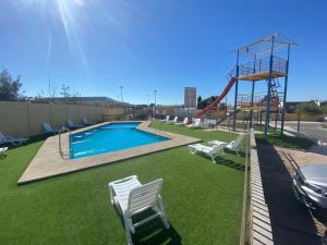 a playground with a pool and a slide at descanso y paz in Caldera