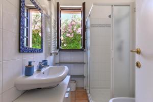 a white bathroom with a sink and a shower at Residenza Elbamare in Capoliveri