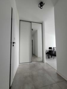 an empty room with a glass door and a table at APARTAMENT OLIWIER in Kłodzko