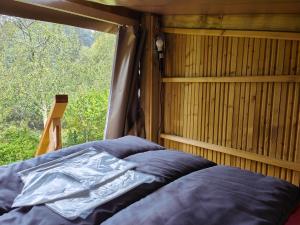 łóżko w pokoju z oknem w obiekcie Camping Onlycamp Les Deux Rives w mieście Lannion