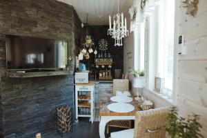 a dining room with a table and chairs and a tv at Guest House Marjala in Kotka