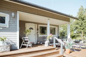 een veranda van een huis met twee stoelen en een deur bij Guest House Marjala in Kotka