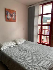 Schlafzimmer mit einem Bett mit einem Schmetterlingsbild an der Wand in der Unterkunft Casa Roma - La tranquilidad del campo en la Ciudad - RNT 1 0 8 1 3 7- in Salento
