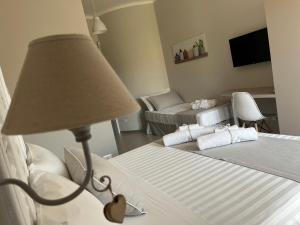 1 dormitorio con 1 cama con lámpara y sofá en B&B L’ALTRAMURGIA, en Cassano delle Murge