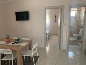 a dining room with a table and chairs and a television at Villa Tunaj Neu 2023 Novo,New in Bar