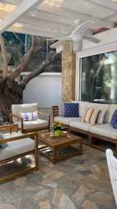 a patio with couches and tables and a tree at Villa eco Electra in Nikiti