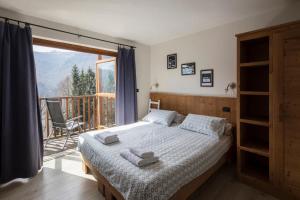 a bedroom with a bed and a large window at Rifugio Galaberna in Ostana