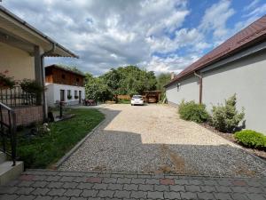 a driveway with a car parked next to a house at Casa LINDA in Turda