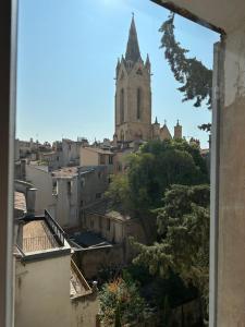 una ventana con vistas a la catedral de una ciudad en CABADOL - Appartement Aix centre historique - très calme - 50m cours Mirabeau, en Aix-en-Provence