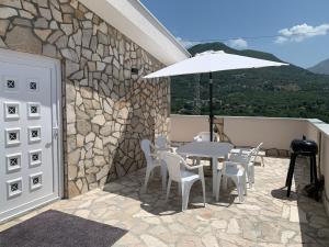 eine Terrasse mit einem Tisch, Stühlen und einem Sonnenschirm in der Unterkunft Villa Tunaj Neu 2023 Novo,New in Bar