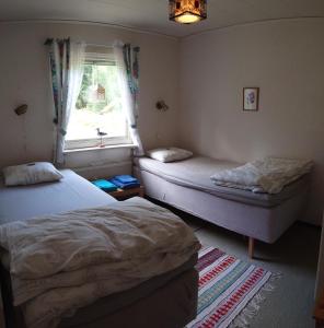 2 camas individuais num quarto com uma janela em Stuga vad vatten em Åsarp