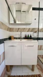 a white kitchen with a sink and a mirror at Villa eco Electra in Nikiti
