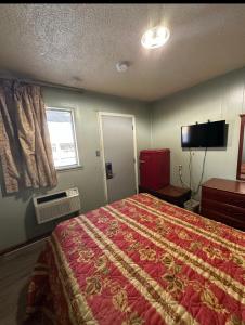a hotel room with a bed and a television at Travel Inn Montgomery AL in Montgomery