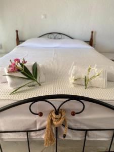 a bed with white sheets and flowers on it at Villa eco Electra in Nikiti