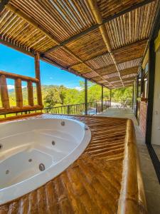 une grande baignoire sur une terrasse en bois avec un toit dans l'établissement Huitaca Ecohotel, à Hispania
