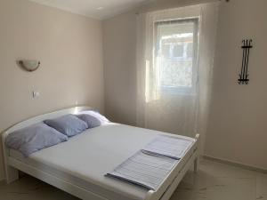 ein weißes Bett in einem weißen Zimmer mit Fenster in der Unterkunft Villa Tunaj Neu 2023 Novo,New in Bar