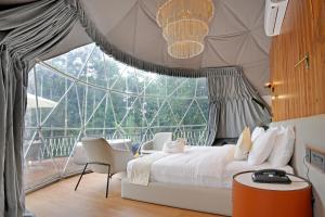a bedroom with a bed and a large window at Le Villagio Resort & Domes in Sultan Bathery +73 photos
