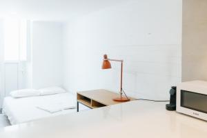 a bedroom with two beds and a desk with a television at Lisboa - Arroios Central Apartment in Lisbon