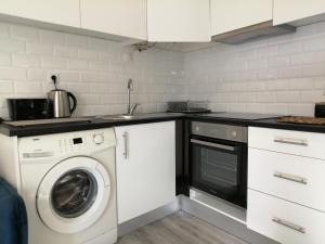 a kitchen with a washing machine and a sink at Cantinho da Karine in Maia