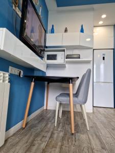 uma secretária com uma televisão e uma cadeira num quarto em Apartment Premium Class in Batumi em Batumi