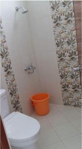 a bathroom with a toilet and an orange bucket at G10 Guest House Near Asia Afrika Bandung in Bandung