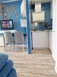 uma cozinha com paredes azuis e uma mesa e cadeiras em Apartment Premium Class in Batumi em Batumi