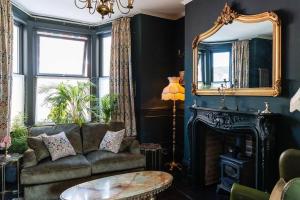 a living room with a couch and a mirror at Cosy vintage townhouse with wood burner in Margate