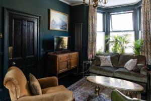 a living room with a couch and a table at Cosy vintage townhouse with wood burner in Margate