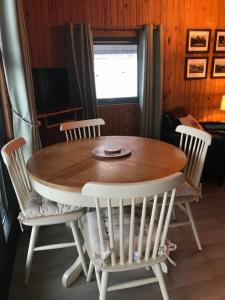 a wooden table with four chairs and a television at Gulls Island in Morenish