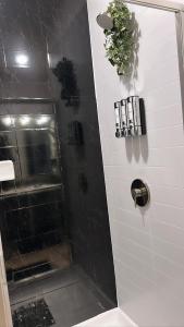 bagno con doccia e piastrelle bianche e nere di The Refuge Retreat a Fort Worth